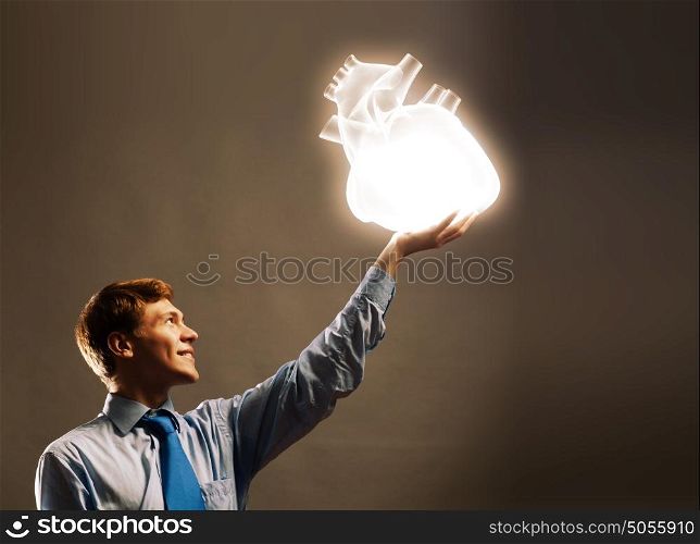Healthy life. Young businessman holding human 3d heart in palm