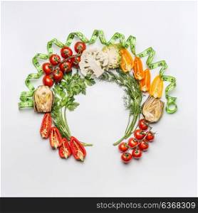 Healthy lifestyle and dieting concept. Round circle frame of various salad vegetables ingredients and greens on white desk background, top view. Clean food and vegetarian eating