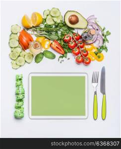 Healthy lifestyle and modern dieting concept. Various fresh salad vegetables with cutlery and measuring tape around PC tablet . Copy space for shopping list, recipes, dieting plan or menu. Top view