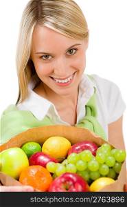Healthy lifestyle - cheerful woman with fruit shopping paper bag on white background