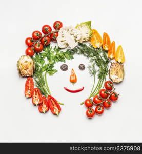 Healthy lifestyle concept. Funny face made with various vegetables ingredients on white background, top view, frame. Detox, dieting and clean eating food