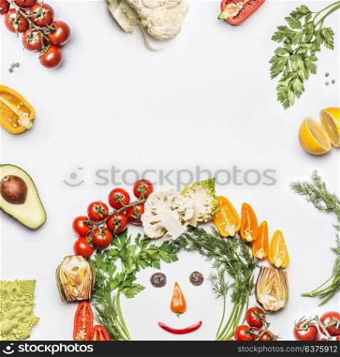 Healthy lifestyle concept. Various fresh vegetables with funny face made with ingredients on white background, top view, frame. Layout for Detox, dieting and clean eating food