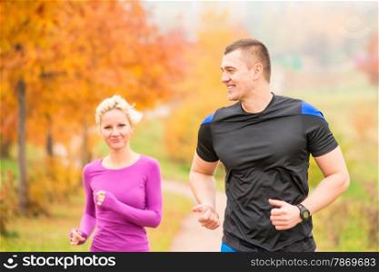 healthy lifestyle - jogging. a man and a woman running in the morning in the park