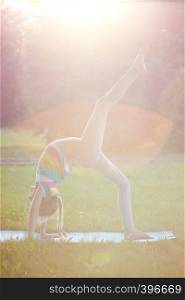 Healthy lifestyle - little girl doing yoga in the park. Healthy and Yoga Concept