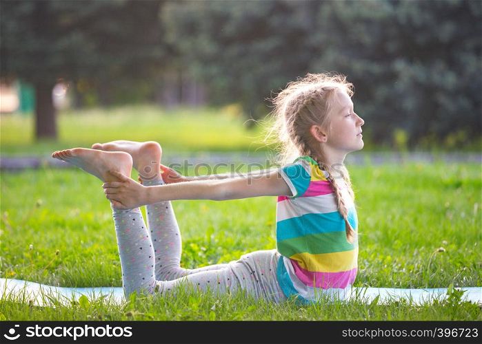 Healthy lifestyle - little girl doing yoga in the park. Healthy and Yoga Concept