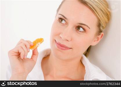Healthy lifestyle - portrait of woman holding tangerine slice on white background