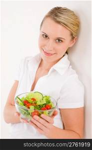Healthy lifestyle - smiling woman with vegetable salad on white