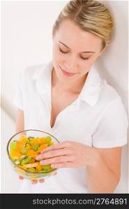 Healthy lifestyle - woman holding bowl with fruit salad on white background