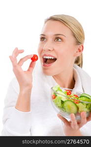 Healthy lifestyle - woman with vegetable salad on white biting tomato