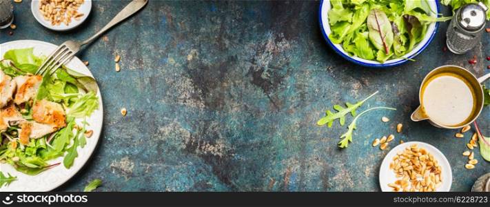 Healthy lunch eating with Chicken salad , pine nuts and oil dressing. Chicken salad with green leaves served on rustic background, top view, place for text, banner