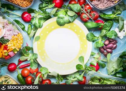 Healthy lunch preparation. Various vegetables and salad bowls in plastic packaging around empty plate, top view, frame