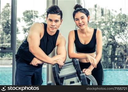 Healthy man and woman doing weight training in gym fitness center. Bodybuilding concept.