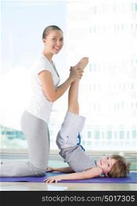 Healthy morning stretching - woman with son doing gymnastic exercise at home