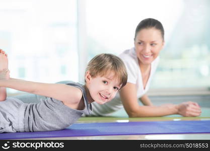 Healthy morning stretching - woman with son doing gymnastic exercise at home