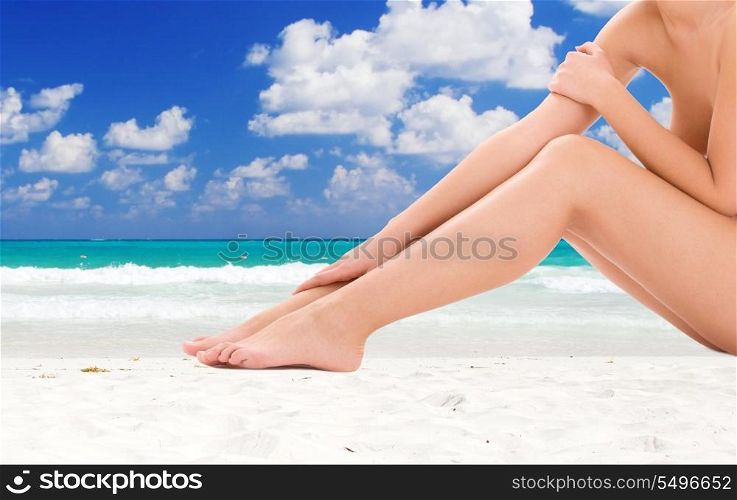 healthy naked woman legs over tropical beach background