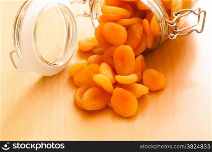 Healthy nutrition and diet. Closeup of glass jar of dried fruits apricots on wooden table. Food.