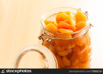 Healthy nutrition and diet. Closeup of glass jar of dried fruits apricots on wooden table. Food.