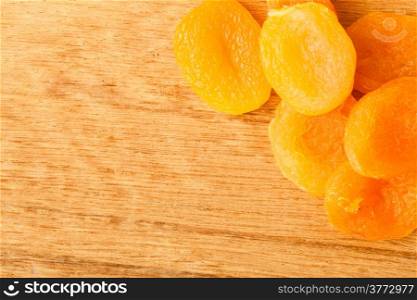 Healthy nutrition diet. Border frame of dried apricots on wooden table background.