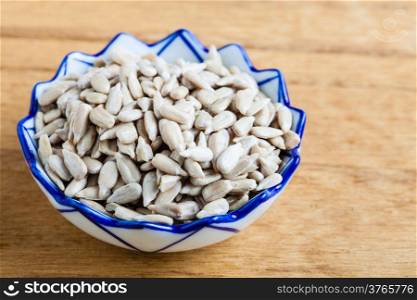 Healthy nutrition diet. Bowl of fresh sunflower seeds on wooden table background.