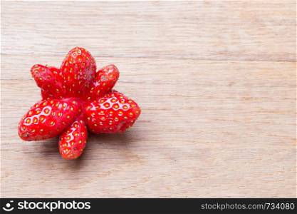 Healthy nutrition diet food modification. Red odd single strawberry fruit on wooden table board copy space text area