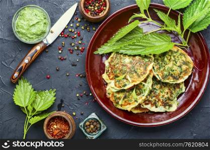 Healthy nutrition, diet fritters with nettles on a plate. Diet fritters with herbs