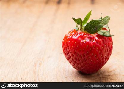 Healthy nutrition diet. Red fresh single strawberry fruit on wooden table board