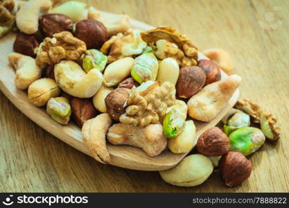 Healthy organic nutrition high fatty acids food and cuisine. Closeup varieties assortment mix of nuts on wooden spoon.