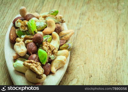 Healthy organic nutrition high fatty acids food and cuisine. Closeup varieties assortment mix of nuts on wooden spoon.