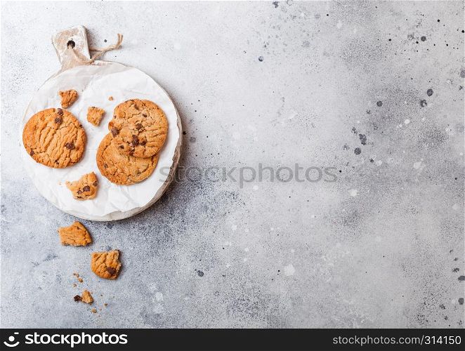Healthy organic oat cookies with chocolate on wooden board on stone kitchen table background.