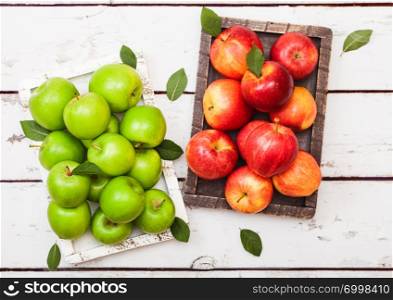 Healthy organic red and green apples in vintage box on wood background.