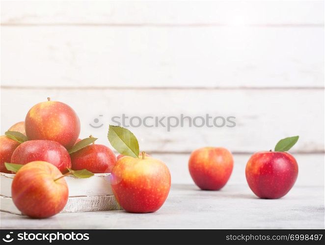 Healthy organic red apples in wooden box on white wooden background with sun light