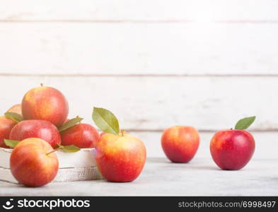 Healthy organic red apples in wooden box on white wooden background with sun light