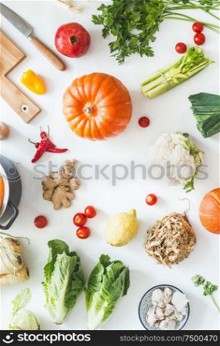 Healthy organic seasonal vegetables on white kitchen desktop with herbs and spices. Top view. Frame. Copy space. Vegetarian cooking and eating. Local food. Blog layout. Pumpkin time.