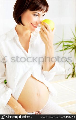 Healthy pregnant lady eating green apple, diet and organic nutrition concept
