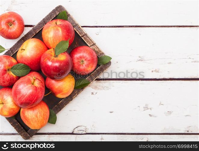Healthy red organic apples in vintage box on wood background.