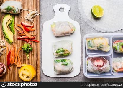 Healthy Rice paper rolls preparation with chopped vegetables and lunch box, top view