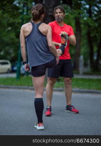 healthy runners team warming up and stretching in city park before morning training. runners team warming up and stretching before morning training