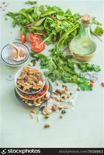 Healthy salad making ingredients. Fresh kitchen herbs. Nuts topping. Olives oil. Salad dressing . Diet or vegetarian food concept.