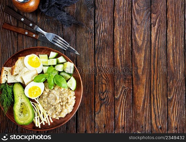 Healthy salad of fresh vegetables - tomatoes, avocado, cucumber, radish, egg, arugula and oatmeal on bowl. Diet food.