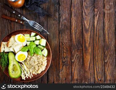 Healthy salad of fresh vegetables - tomatoes, avocado, cucumber, radish, egg, arugula and oatmeal on bowl. Diet food.