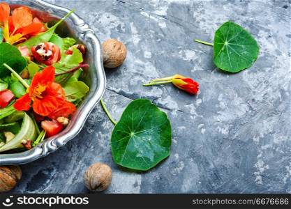 Healthy salad with flowers, nasturtium leaves, tomatoes and nuts. Indian salad.Diet food. Summer nasturtium salad