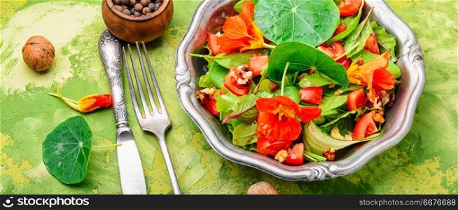 Healthy salad with flowers, nasturtium leaves, tomatoes and nuts. Indian salad.Diet food. Fresh summer salad with nasturtium
