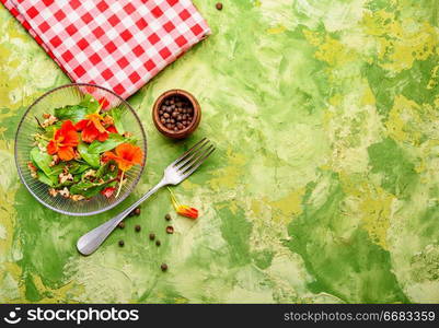 Healthy salad with flowers, nasturtium leaves, tomatoes and nuts.Summer food.Indian salad.Capuchin. Salad with flowers of nasturtium