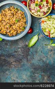 Healthy salads on rustic background, top view
