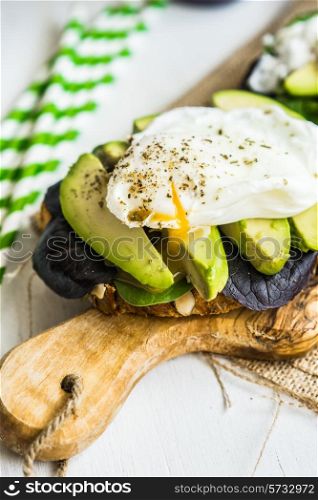 Healthy sandwich with avocado and poached eggs
