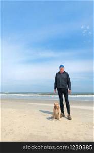 Healthy senior man as runner with his dog at the beach