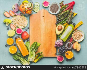 Healthy smoothie ingredients around wooden cutting board, top view. Summer food and beverages background. Vegan superfood: Fruits, berries and vegetables, chia seeds, almond, pine nuts. Detox concept