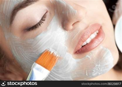 Healthy spa: young beautiful relaxing woman having moistening mask applied