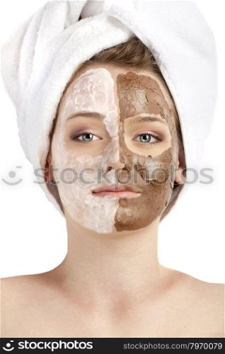 Healthy spa: young beautiful woman having two moistening masks applied: chocolate and white. Her head is wrapped up by a towel.