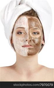 Healthy spa: young beautiful woman having two moistening masks applied: chocolate and white. Her head is wrapped up by a towel.